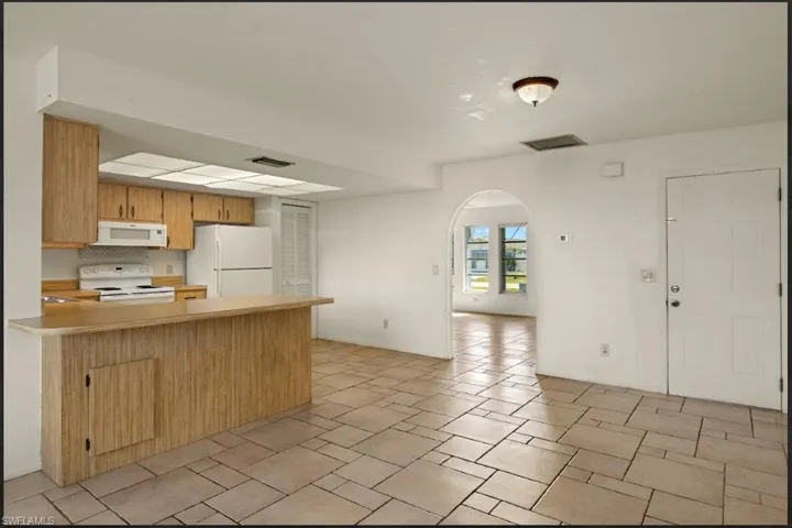Kitchen featuring white appliances and kitchen peninsula