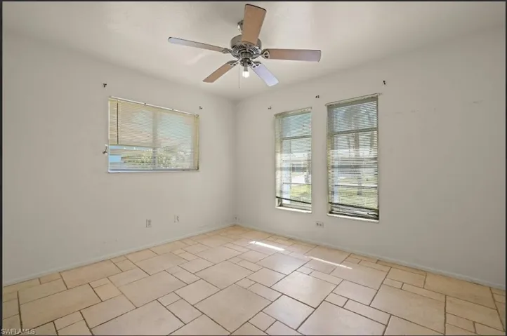 Unfurnished room with a healthy amount of sunlight and ceiling fan