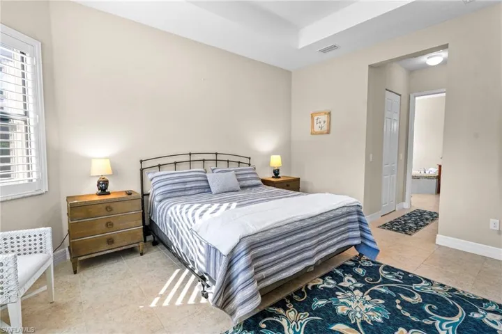 Bedroom featuring connected bathroom and light tile patterned flooring