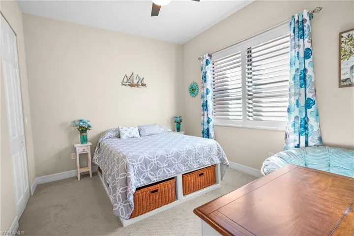 Carpeted bedroom with a closet and a ceiling fan