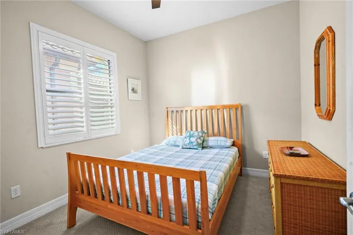 Carpeted bedroom featuring a ceiling fan and baseboards