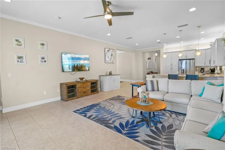 Living room featuring crown molding, recessed lighting, ceiling fan, and light tile patterned floors