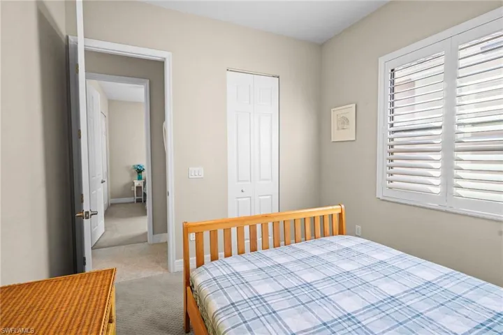 Bedroom with light carpet and a closet