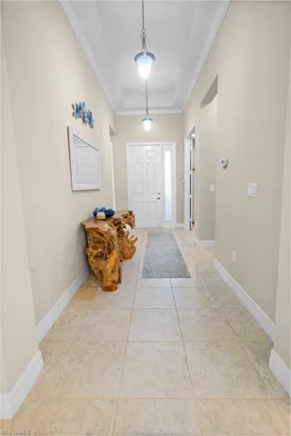 Foyer featuring light tile patterned floors and ornamental molding