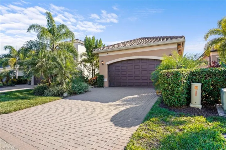 Mediterranean / spanish house featuring decorative driveway, stucco siding, a tile roof, and an attached garage