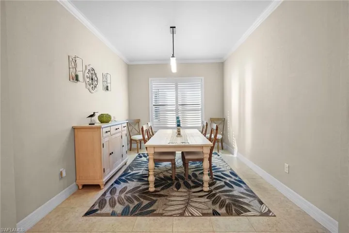 Dining area with baseboards and ornamental molding