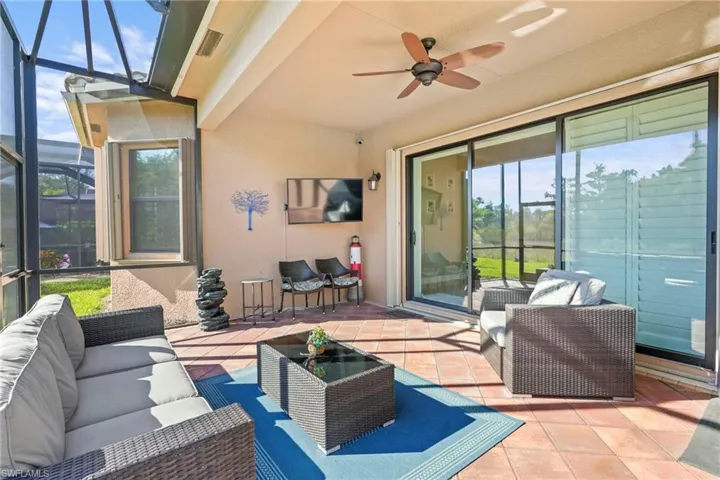 View of patio / terrace featuring a lanai, a sunroom, an outdoor living space, and a ceiling fan