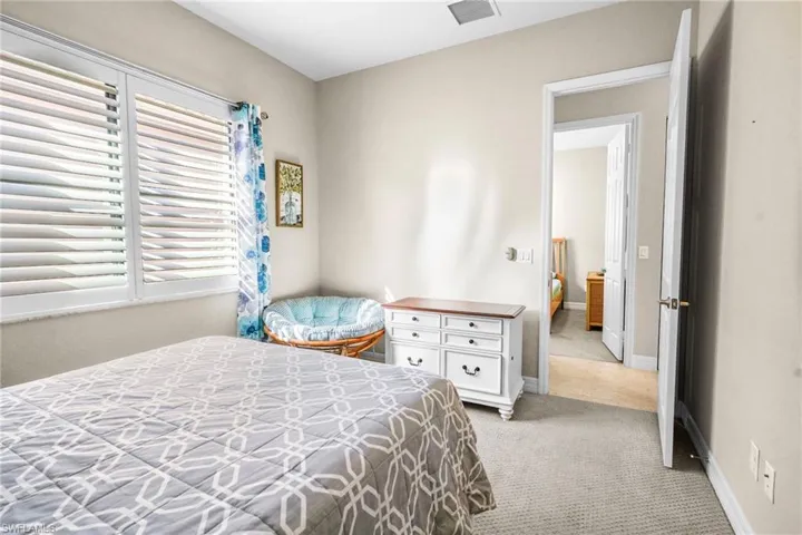 Bedroom featuring light colored carpet and baseboards