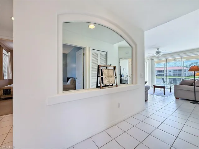 Hallway with baseboards and light tile patterned floors