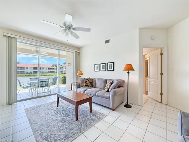 Living area with light tile patterned floors, visible vents, and ceiling fan