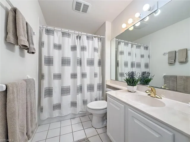 Bathroom with visible vents, toilet, tile patterned flooring, and vanity