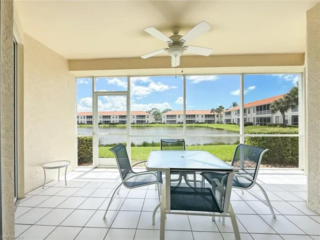 Sunroom featuring a water view, outdoor dining area, ceiling fan, and a residential view