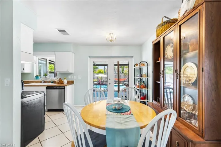 Tiled dining area with sliding doors and part of kitchen