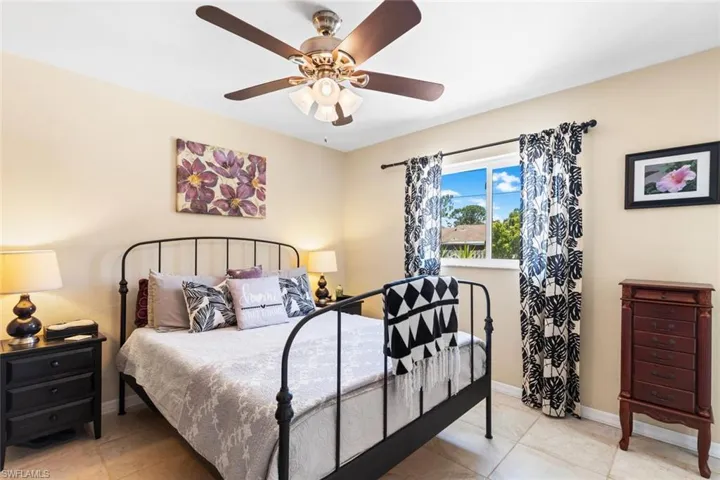 Primary Bedroom with ceiling fan and light tile floors