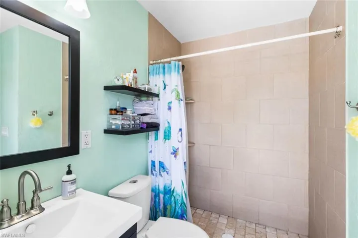 Primary Bathroom with walk in shower, vanity, and toilet