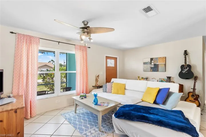 Living room Entrance featuring ceiling fan and light tile floors