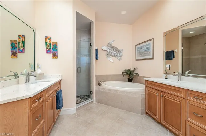 OWNER'S SUITE BATH WITH DUAL QUARTZ-TOPPED VANITIES.  SOAKER TUB WITH TILED SURROUND.  RECESSED LIGHTING.  SHOWER.