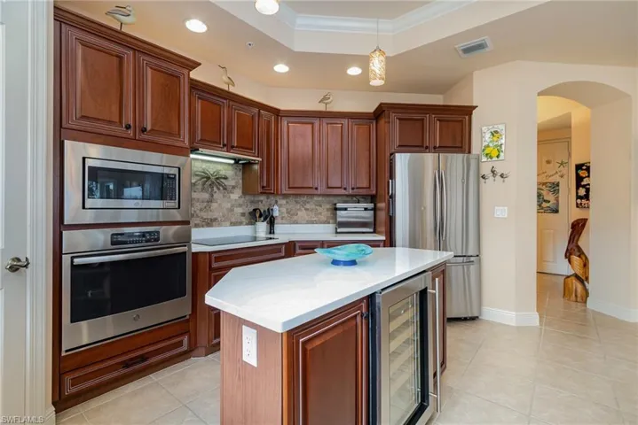 WALL OVEN.  MICROWAVE.  FULL HEIGHT TILED BACKSPLASH.  QUARTZ COUNTERTOPS.  RECESSED AND PENDANT LIGHTING.