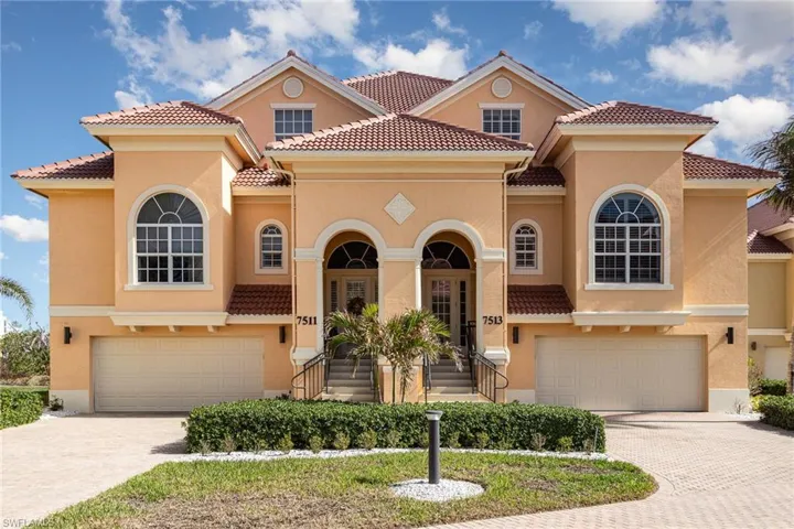 EXTERIOR OF HOME.  UNIT ON RIGHT SIDE.  PAVERED DRIVEWAY.  GARAGE ACCOMMODATES A COMBINATION OF 4 CARS OR BEACH TOYS AND CARS.  LARGE ARCHED WINDOW IS TO WEST-FACING GUEST SUITE.  SMALL ARCHED WINDOW IS TO LAUNDRY ROOM.