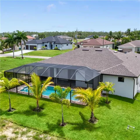 Back of property with a lanai and a lawn