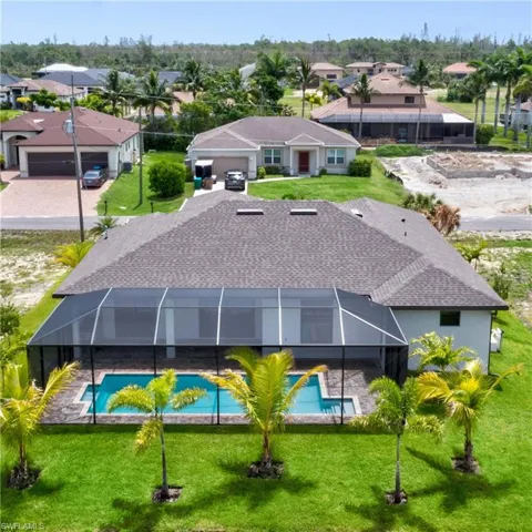 Rear view of house with a yard and a lanai