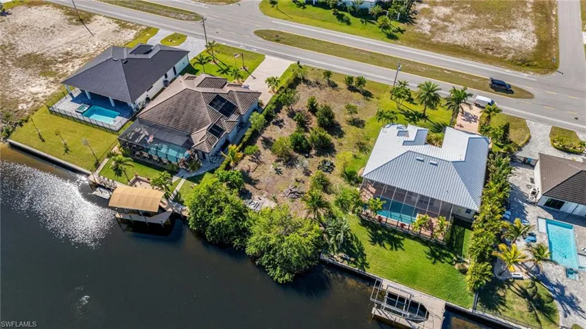 Birds eye view of property featuring a water view and a residential view