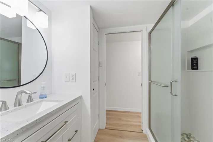 Bathroom featuring a shower stall, vanity, and light wood-type flooring