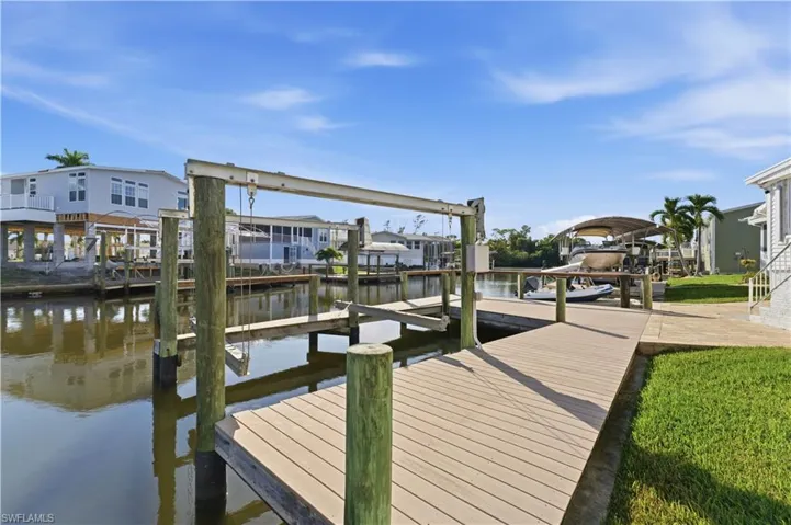 Dock area with boat lift, a residential view, and a water view
