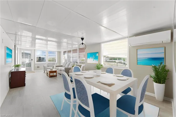 Dining room with a wall mounted air-conditioner and plenty of natural light-virtually staged