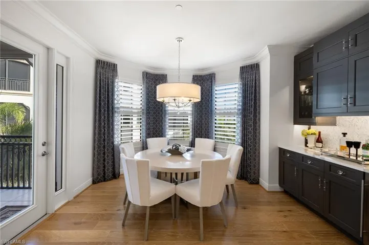 Dining room with a notable chandelier, crown molding, and light wood-type flooring