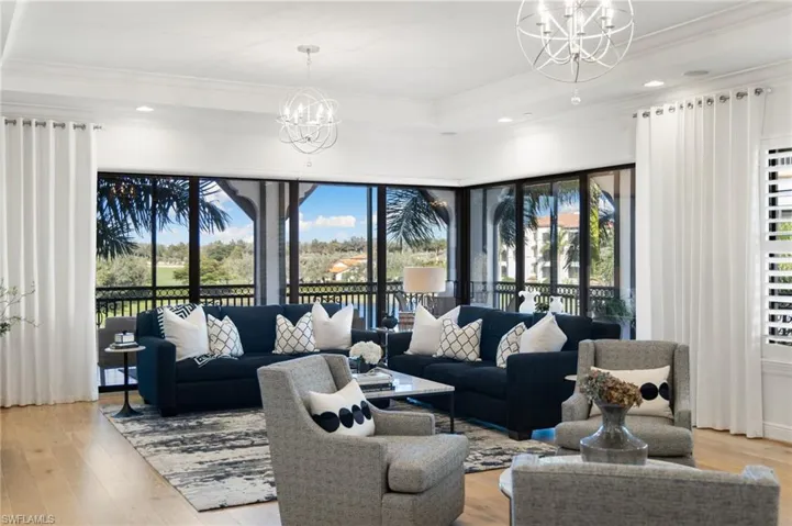Living room with an inviting chandelier, crown molding, and light hardwood / wood-style floors