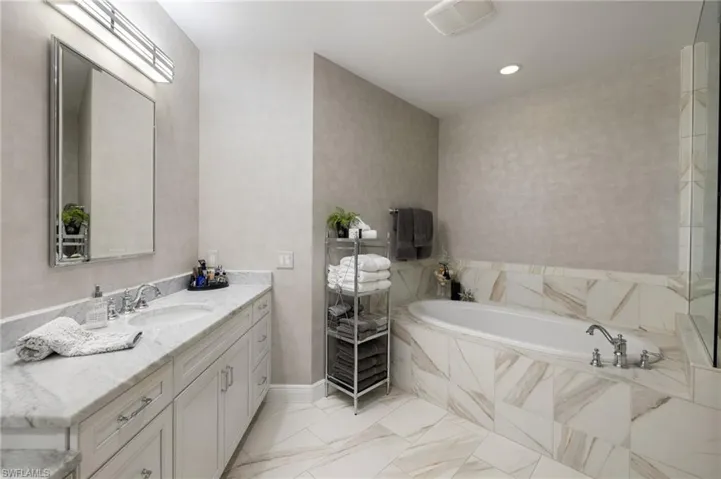 Bathroom with vanity and tiled tub