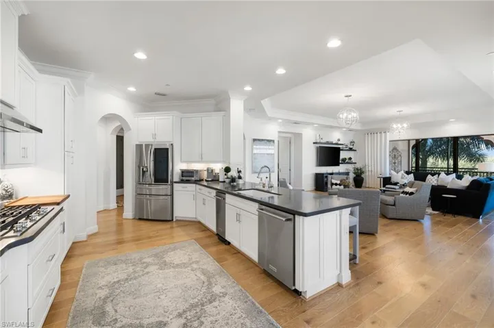 Kitchen with light wood-type flooring, appliances with stainless steel finishes, sink, and white cabinets