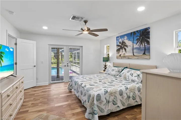 Spacious primary suite with direct access to the outdoor pool and lanai, blending indoor and outdoor living.