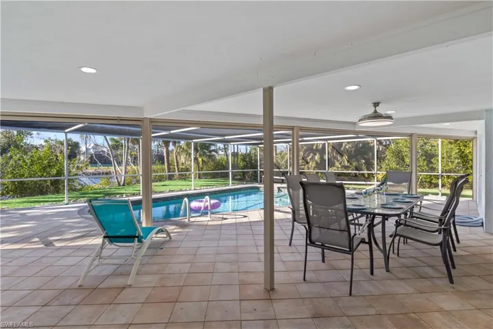 Expansive outdoor living area with pool, covered patio, and seamless indoor-outdoor flow.