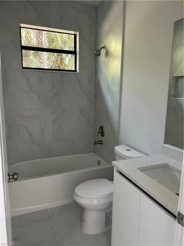 Full bathroom with vanity, toilet, and tiled shower / bath