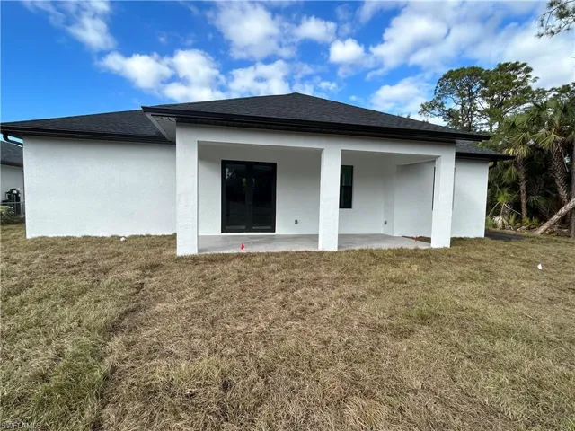 Back of house with a patio area and a yard
