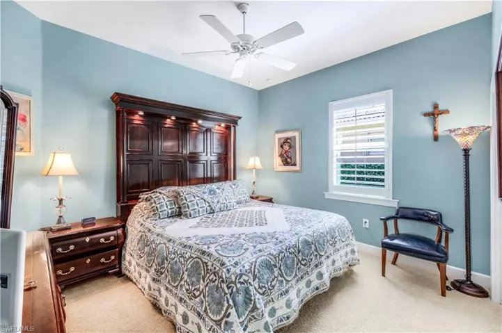 2nd bedroom featuring light carpet and ceiling fan, plantation shutters.