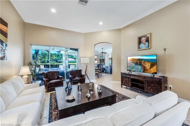 Living room with light tile patterned floors and crown molding. Access to your covered lanai and pool area.