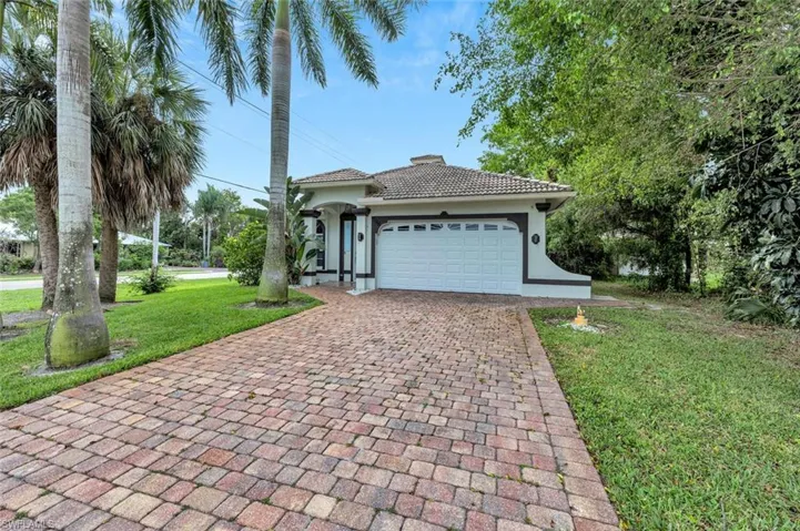 View of front of property with a garage and a front lawn