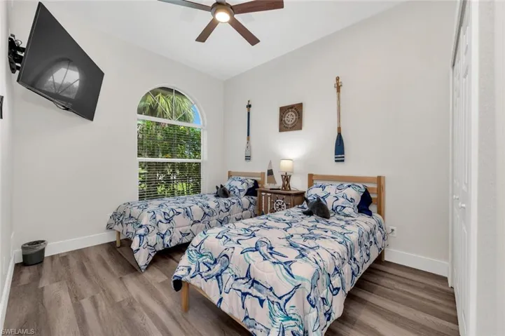 Bedroom with lofted ceiling, ceiling fan, and light wood-type flooring