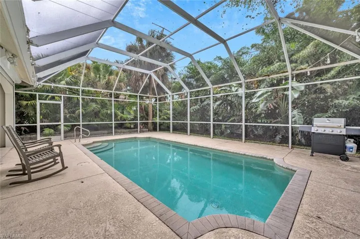 View of swimming pool with a lanai, a patio, and a grill