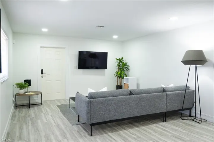 Living area with light wood-style floors and recessed lighting