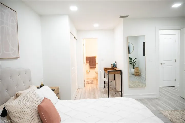 Bedroom featuring light wood finished floors, recessed lighting, and connected bathroom