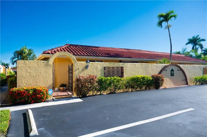 Mediterranean / spanish-style home with uncovered parking, a tile roof, and stucco siding
