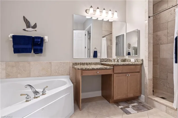 Bathroom with tile floors, shower with separate bathtub, and oversized vanity