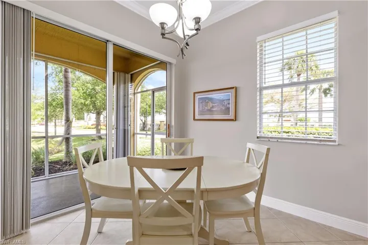 Dining room featuring a wealth of natural light, ornamental molding, a chandelier, and light tile floors