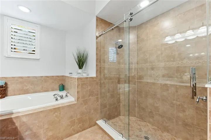 Full bathroom featuring a stall shower and a bath