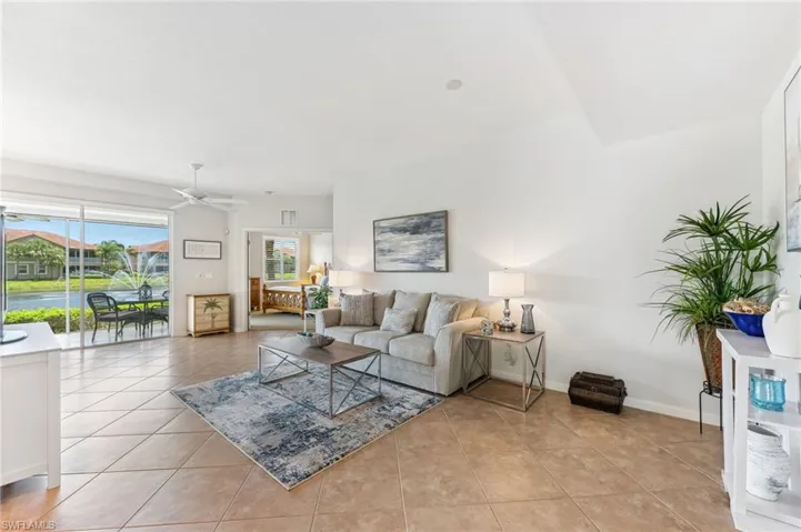 Living room featuring light tile patterned floors and a ceiling fan