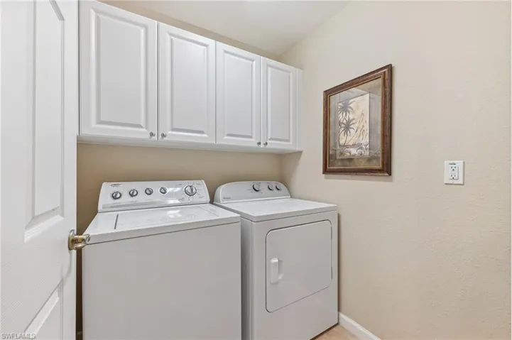 Washroom featuring cabinet space and washing machine and clothes dryer